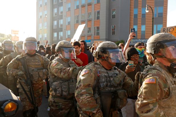 A group of military personnel standing in front of a crowd.