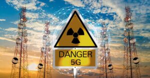 A sign that says danger 5g in front of a group of radio towers.