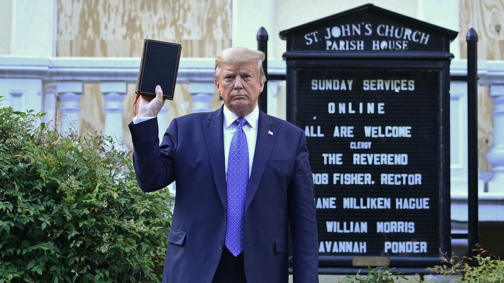 Donald trump holds up a bible in front of a church.