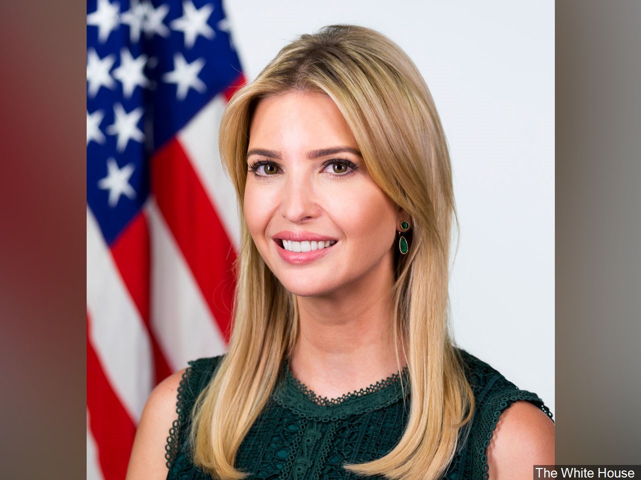 A woman is posing for a photo with an american flag.