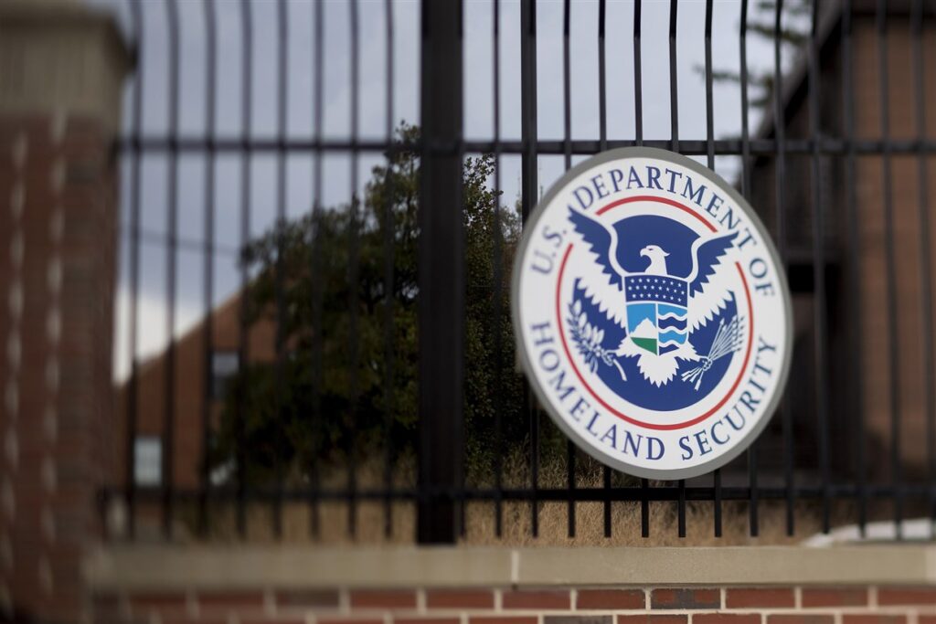 The u s immigration and customs service logo is seen on a fence.