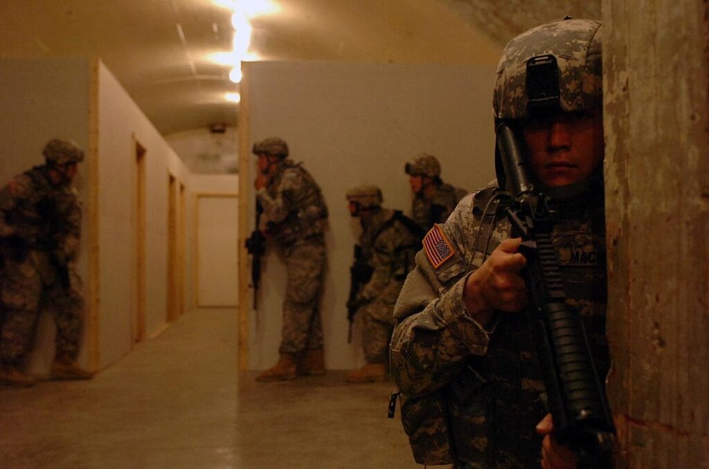A group of soldiers standing in a hallway with a rifle.