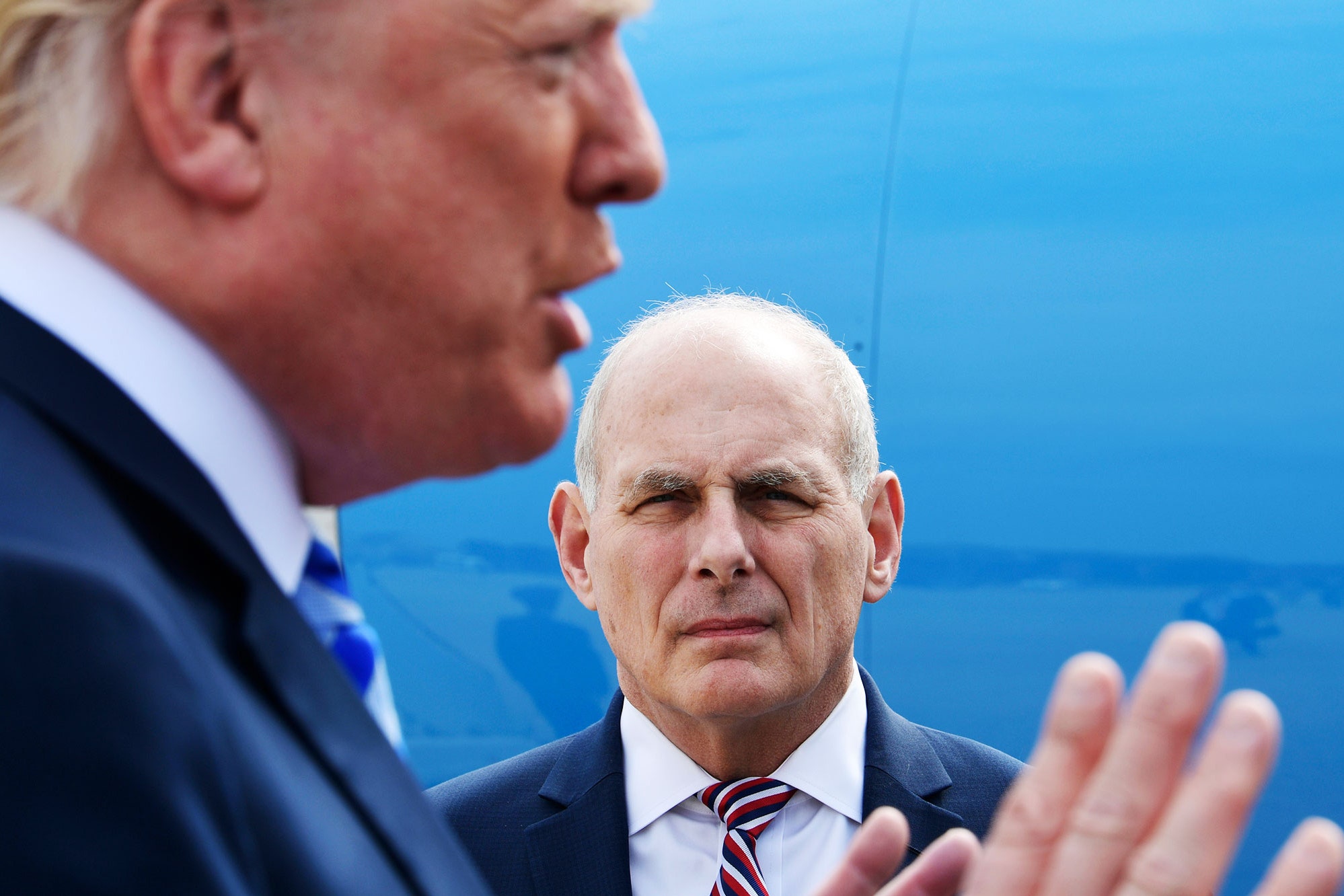 A man in a suit and tie is talking to a man in a suit.