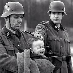 A group of soldiers holding a baby in their arms.