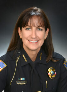 A woman in a police uniform smiling for the camera.