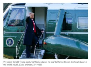 President donald trump waves as he exits his helicopter.