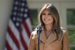 Melania Trump with Mic and Flag in the Back