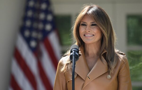 Melania Trump with Mic and Flag in the Back