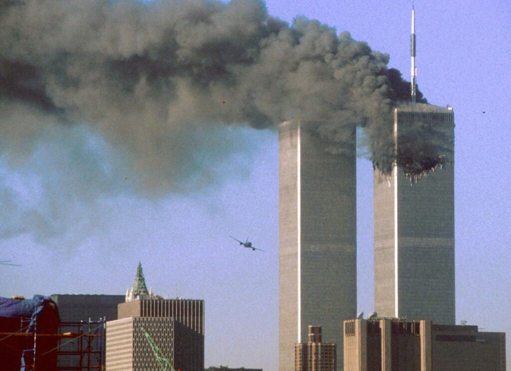 A black smoke billows from the twin towers in new york city.