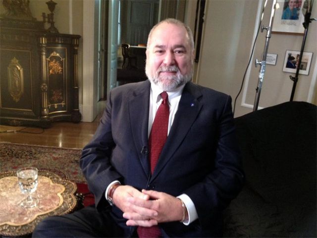 A man in a suit sitting on a couch.