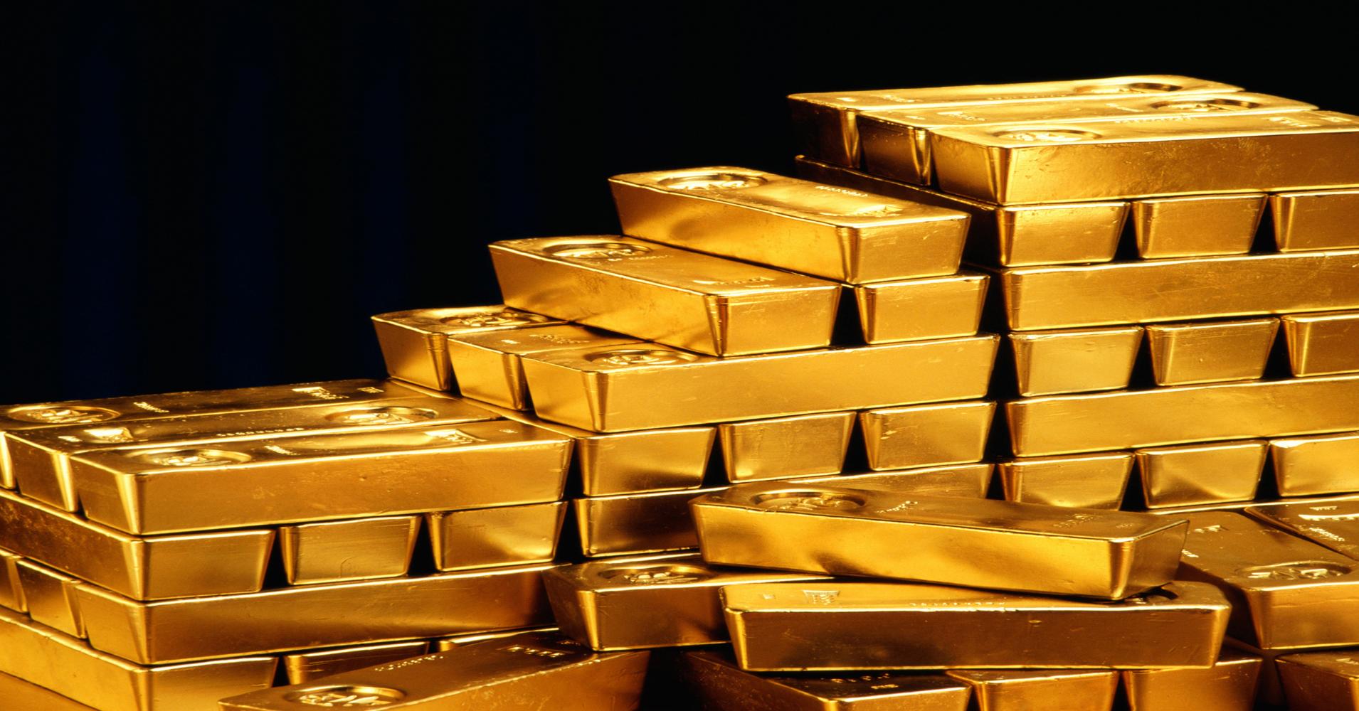 A pile of gold bars on a black background.