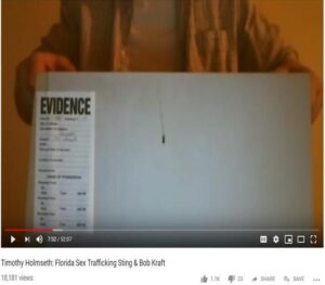 A man is holding up a piece of paper with evidence on it.