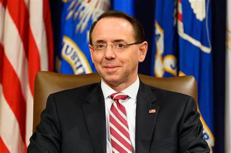 A man in a suit and tie sitting at a desk.