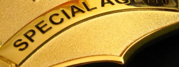 A gold badge with the words special agent on it.