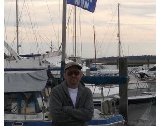 Timothy Holmseth standing near boats