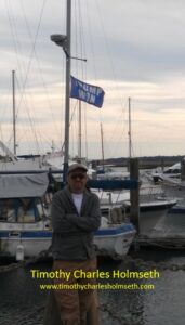 Timothy charles holmesh standing in front of a boat.