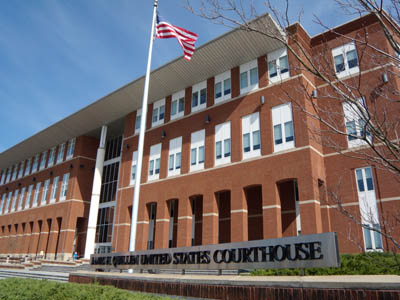 The us supreme court building is in front of an american flag.