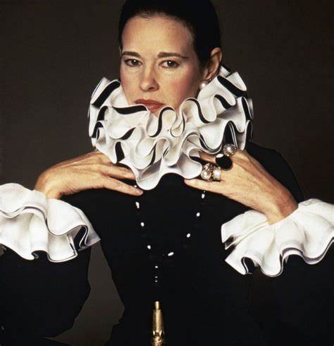 A woman wearing a black and white dress with a ruffled collar.