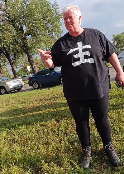 A woman in a black t-shirt standing in the grass.