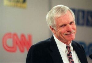 A man in a suit and tie standing in front of a cnn logo.