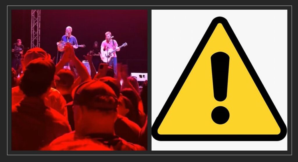 A picture of a concert with a warning sign in the background.