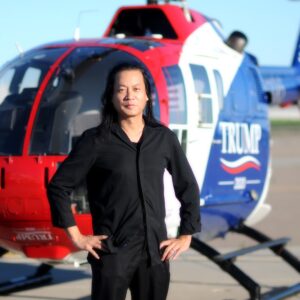 A man standing in front of a helicopter.